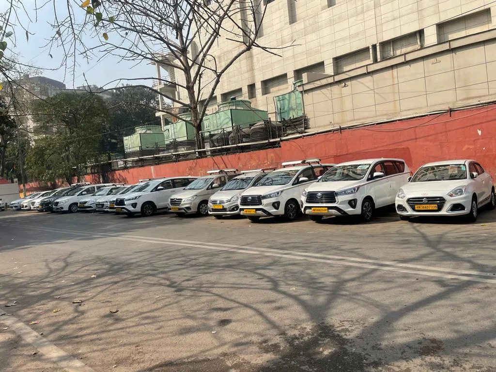 Part of the Pal Tour and Travels fleet parked in a row: Innovas, Ertigas and Dzires